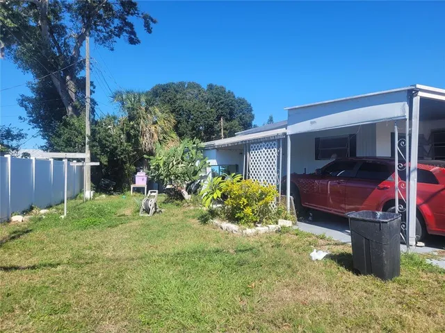 a view of backyard with a barn and a large tree