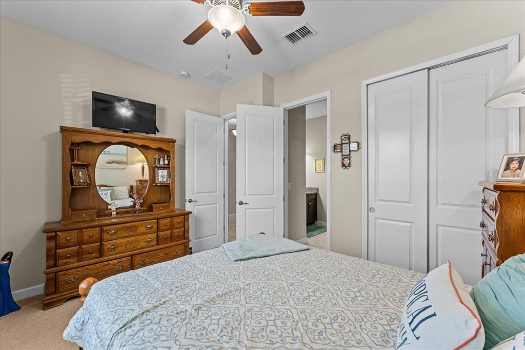 13443 White Sapphire Road Riverview, FL 33579 - Photo 24 of 47 a bedroom with a bed and a flat tv screen on dresser