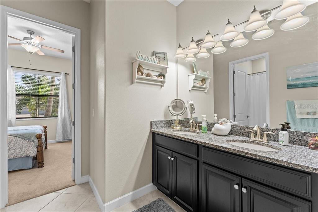 13443 White Sapphire Road Riverview, FL 33579 - Photo 25 of 47 a bathroom with a granite countertop double vanity sink mirror and window
