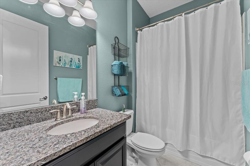 13443 White Sapphire Road Riverview, FL 33579 - Photo 30 of 47 a bathroom with a granite countertop sink toilet and a mirror