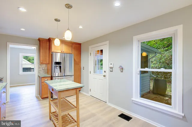 a kitchen with granite countertop a stove a sink and a wooden floors