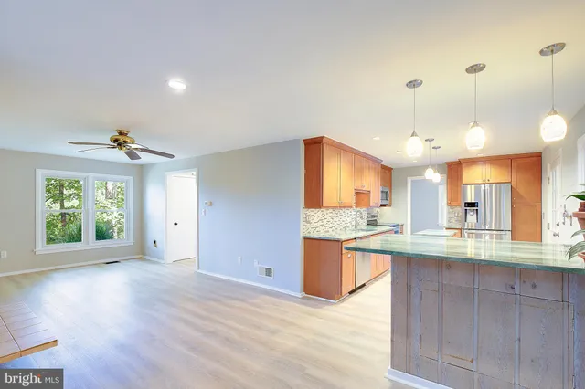 a living room with kitchen island a table and a sink