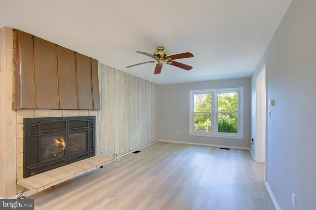 a view of a big room with wooden floor and windows
