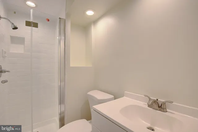 a bathroom with a sink mirror vanity and toilet