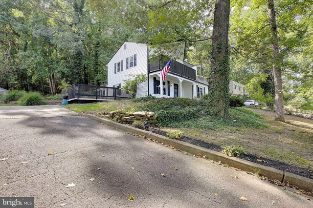 a view of a house with a yard and large trees