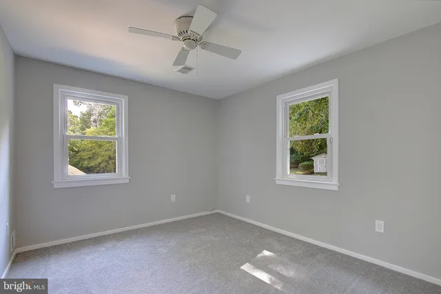 an aerial view of a house with a yard and large trees