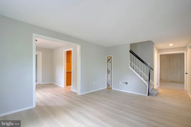 a view of a livingroom with wooden floor and a ceiling fan