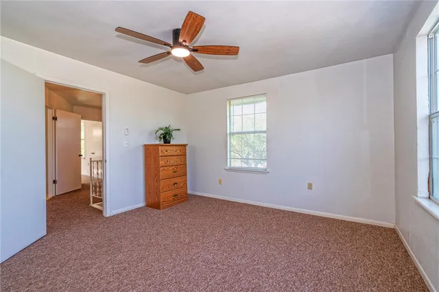a view of a livingroom with a ceiling fan and window