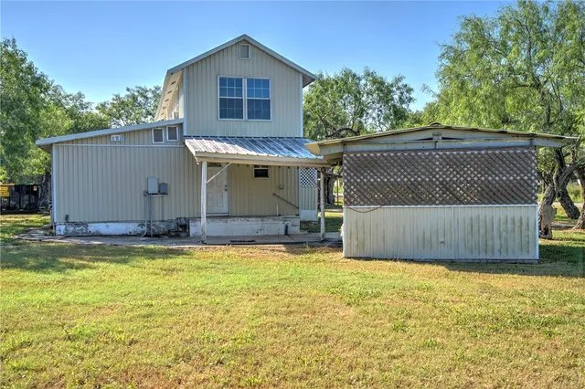 a view of a house with a swimming pool and a yard