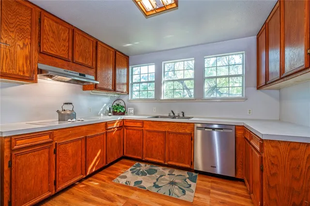 a kitchen with stainless steel appliances granite countertop wooden cabinets a sink and dishwasher