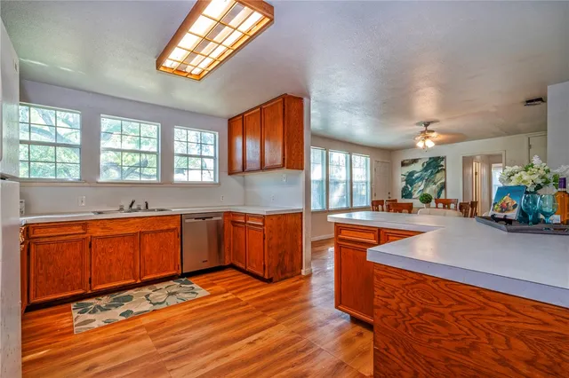 a large kitchen with stainless steel appliances granite countertop a sink wooden cabinets and a granite counter tops