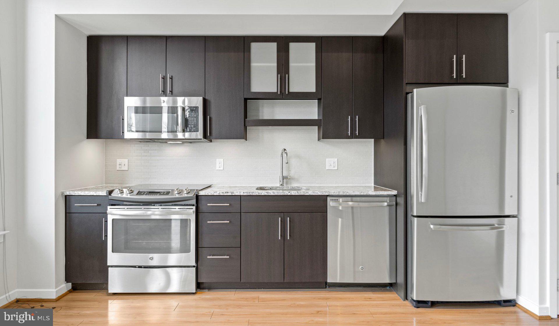 8300 Wisconsin Avenue, Unit 1B1809 Bethesda, MD 20814 - Photo 90 of 150 a kitchen with stainless steel appliances granite countertop a refrigerator and a stove
