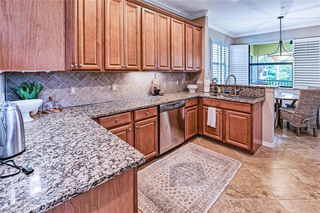 9107 Napoli Court, Unit 201 Naples, FL 34113 - Photo 11 of 35 a kitchen with stainless steel appliances granite countertop wooden cabinets a sink and dishwasher