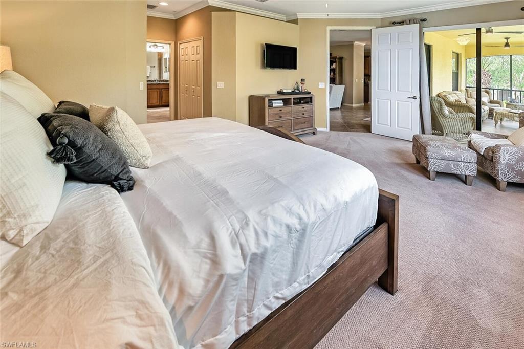 9107 Napoli Court, Unit 201 Naples, FL 34113 - Photo 16 of 35 a spacious bedroom with a bed and large windows