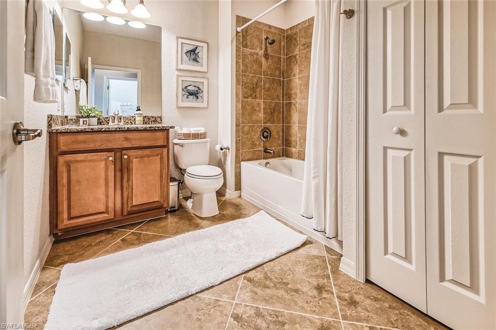 9107 Napoli Court, Unit 201 Naples, FL 34113 - Photo 20 of 35 a spacious bathroom with a mirror a bathtub and a shower