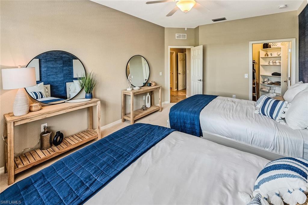 9107 Napoli Court, Unit 201 Naples, FL 34113 - Photo 24 of 35 a bedroom with a bed and a dresser with wooden floor