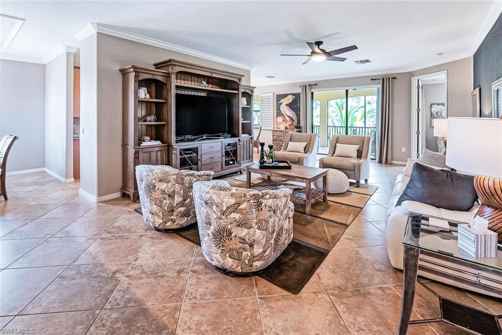 9107 Napoli Court, Unit 201 Naples, FL 34113 - Photo 7 of 35 a living room with furniture a flat screen tv and a floor to ceiling window