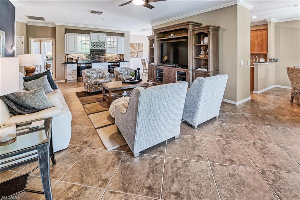 9107 Napoli Court, Unit 201 Naples, FL 34113 - Photo 8 of 35 a living room with patio furniture and a flat screen tv