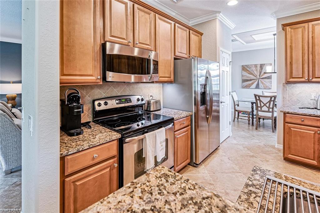 9107 Napoli Court, Unit 201 Naples, FL 34113 - Photo 10 of 35 a kitchen with stainless steel appliances granite countertop a stove a sink and a microwave