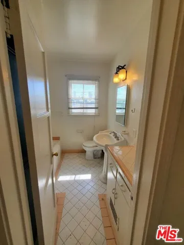 a bathroom with a sink a toilet and a mirror