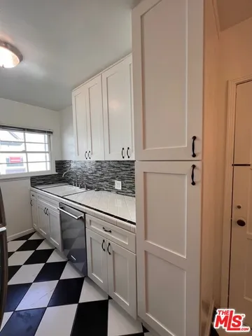 a kitchen with stainless steel appliances granite countertop white cabinets and sink