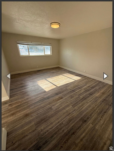 106 East Richelman Lane Wellington, UT 84542 - Photo 4 of 35 Unfurnished room with dark wood-style floors and a textured ceiling