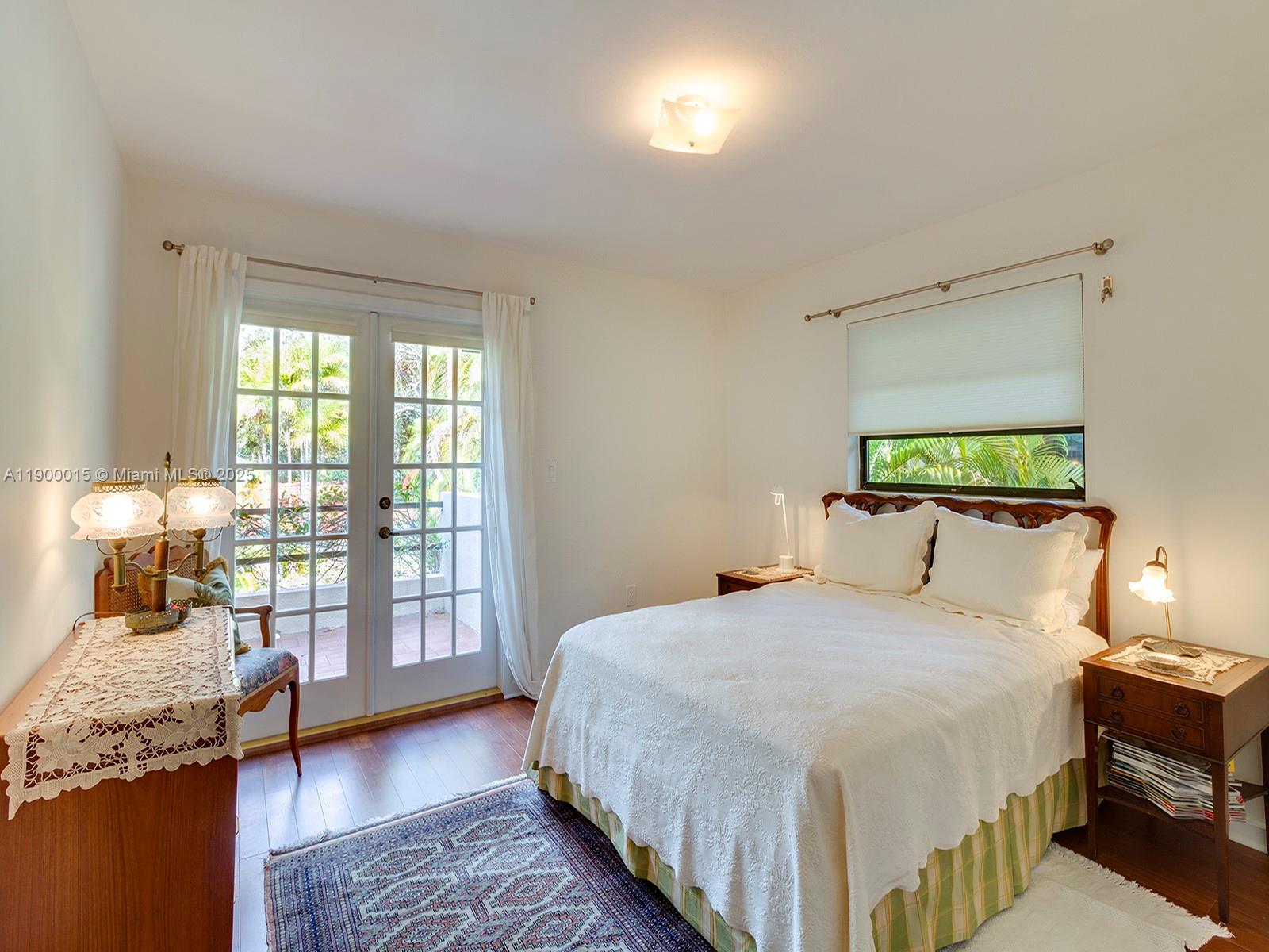 7950 Old Cutler Road Coral Gables, FL 33143 - Photo 26 of 30 a bedroom with a large bed and a wooden floor