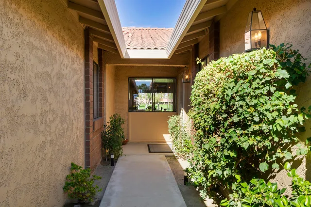 a view of a pathway of a house with potted plants