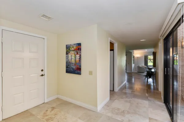 a view of a hallway with wooden floor and a living room