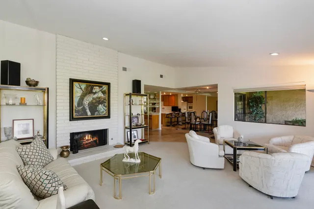 a living room with furniture a fireplace and a large window