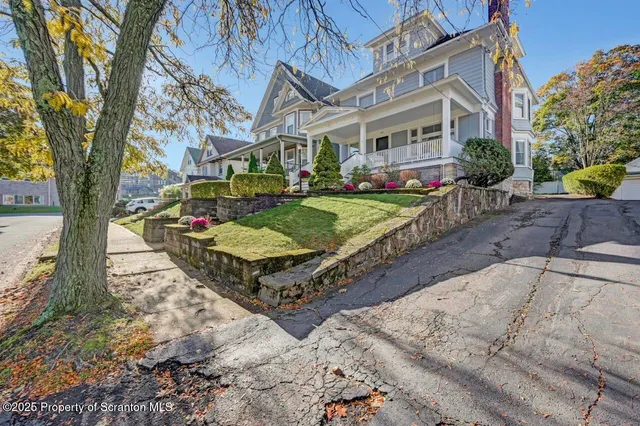 a front view of a house with a yard and fountain in middle