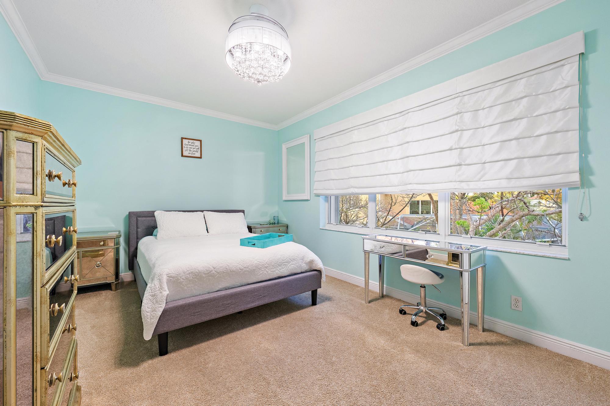 265 Swallowtail Lane Jupiter, FL 33458 - Photo 16 of 37 a bedroom with a bed and a chandelier