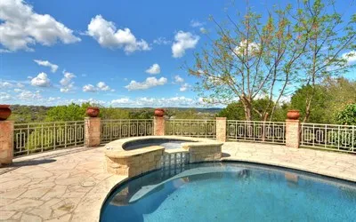a view of a swimming pool with a patio and a yard