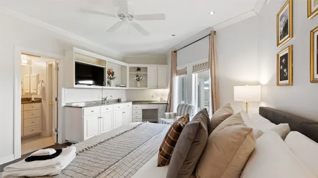 a large bedroom with a bed flat screen tv and glass door