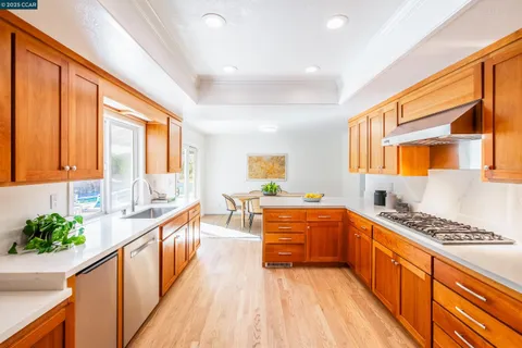 a large kitchen with stainless steel appliances kitchen island granite countertop a large stove a sink dishwasher and cabinets with wooden floor