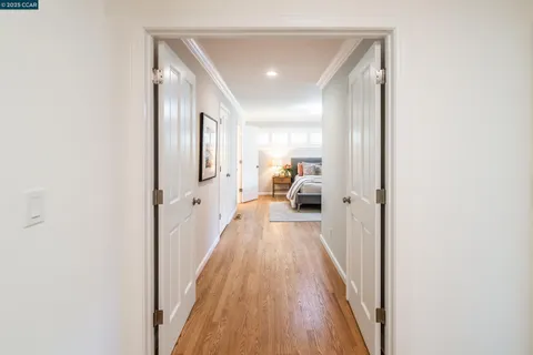 a view of a hallway with wooden floor and furniture