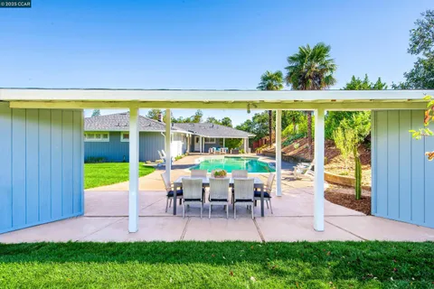 a view of a chairs and table in patio with a yard