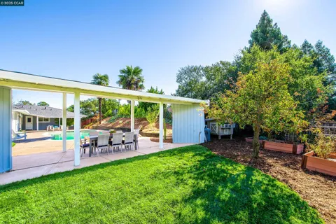 a view of a patio with table and chairs potted plants and large tree