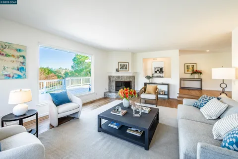 a living room with furniture fireplace and a large window