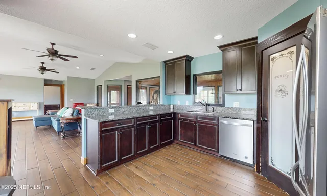 a view of a lake with a yard and a large tree