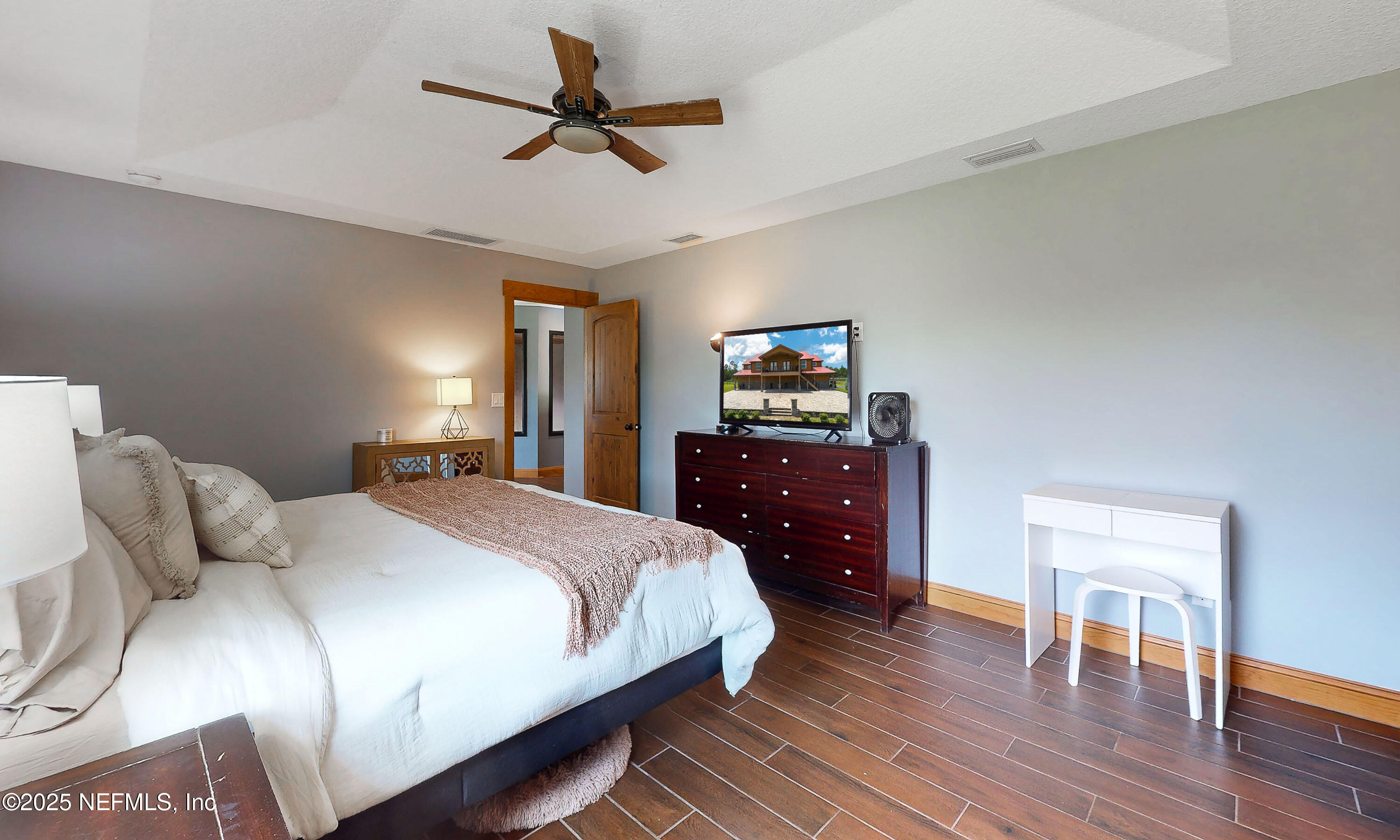 1845 Kinard Road Bryceville, FL 32009 - Photo 31 of 86 a bedroom with a bed a dresser and wooden floor