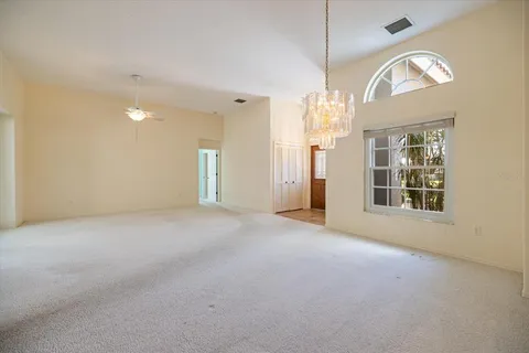 a view of a big room with windows and chandelier