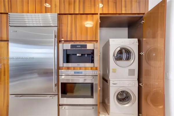 a kitchen with kitchen island granite countertop a refrigerator and cabinets
