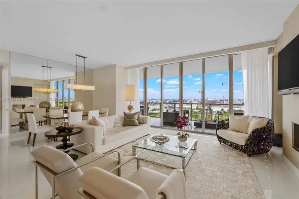 a living room with furniture floor to ceiling window and a flat screen tv