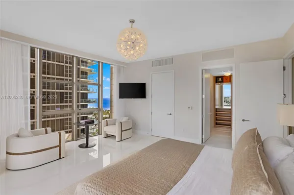 a bedroom with a bed and a chandelier