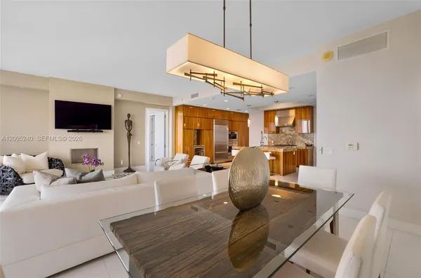 a kitchen with a sink a counter top space and living room view