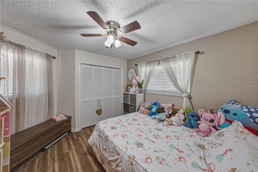 7435 Kilbride Court Weeki Wachee, FL 34613 - Photo 31 of 67 a bedroom with a bed and a chandelier