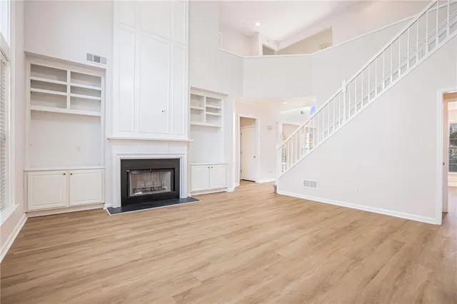 a view of empty room with wooden floor and fireplace