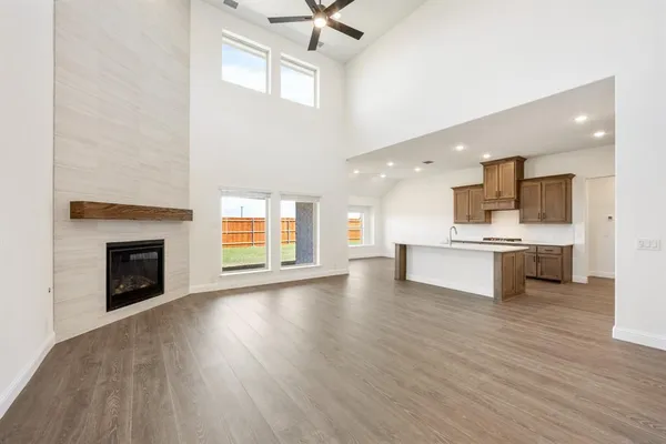 a view of kitchen with granite countertop a stove top oven a sink dishwasher and a fireplace with wooden floor