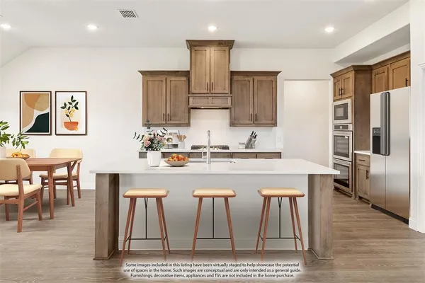 a kitchen with stainless steel appliances granite countertop a table chairs microwave and sink